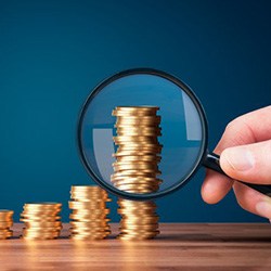 Stacks of coins examined with magnifying glass