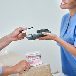 A young man paying for his dental care