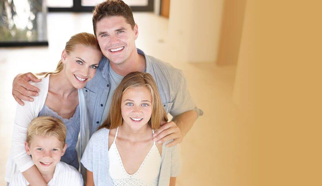Happy family of four smiling after visiting their dentist