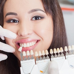 Woman's smile compared with dental bonding shade chart