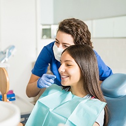 Patient with braces smiling in mirror with McKinney orthodontist