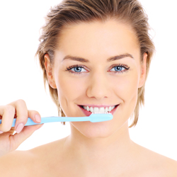 Lady brushing teeth to care for dental crown and bridge