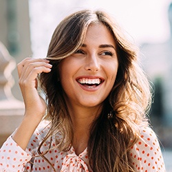 Lady in spotted shirt smiling after Lumineers treatment