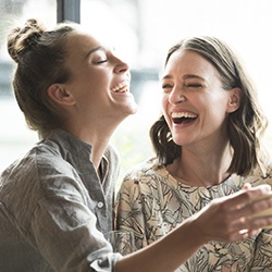 Two ladies with metal free dental restorations laughing together