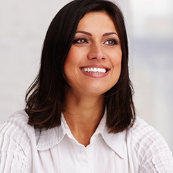 Lady in white blouse smiling after teeth whitening