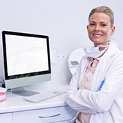 A dentist folding her arms and smiling during emergency dentistry visit