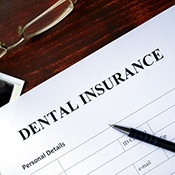 A dental insurance form, glasses, and X-ray on a table