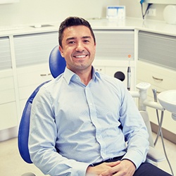 Smiling male dental patient receiving postoperative dental care