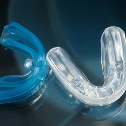 Blue and clear mouthguards with dark background