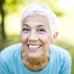 Senior woman with dental implant supported dentures grinning from ear to ear