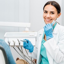 Smiling dentist answering dental implant frequently asked questions