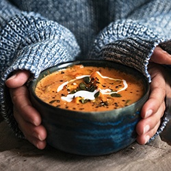 Woman holding bowl of soup