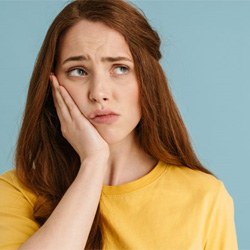 Woman with toothache, wearing worried expression