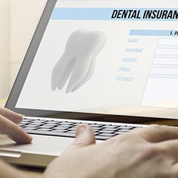 Person filling out dental insurance information on a laptop
