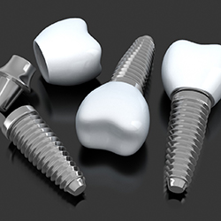 Three dental implants lying on a flat surface