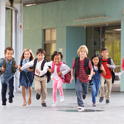 Group of children happily running together after preventive children's dentistry