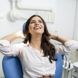 Woman smiling while sitting in dentist's treatment chair 