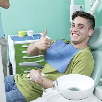 Man smiling and giving thumbs up after oral cancer screening