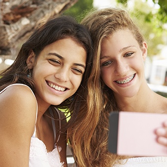 Two Girls taking selfies together after receiving orthodontic treatment