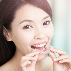 Patient placing Invisalign clear braces tray