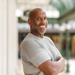 Man smiles confidently after full mouth reconstruction in McKinney