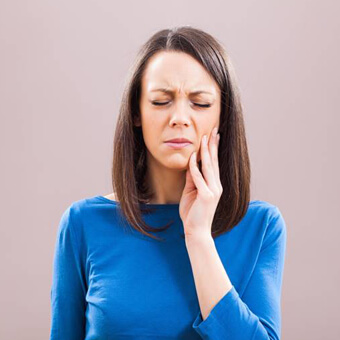 Woman with a toothache before root canal therapy
