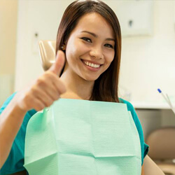 Woman giving thumbs up after root canal therapy