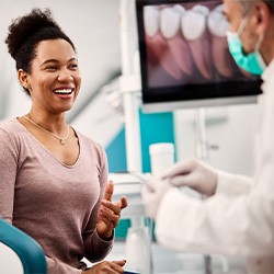 Smiling patient talking to dentist in treatment room