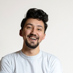 Man with braces in McKinney smiling on white background