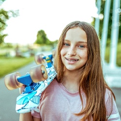 Teen girl with skateboard and braces in McKinney