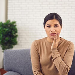 a woman holding her mouth in pain