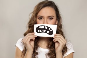 Woman holding picture of broken teeth