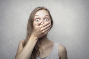 Young woman covering her mouth with hand