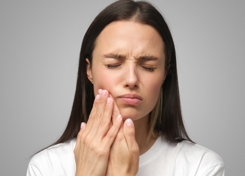 Woman holding jaw in pain
